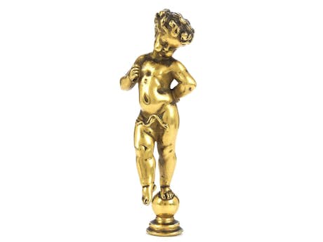 Kleine vergoldete Bronzefigur eines Putto, auf einer Kugel stehend